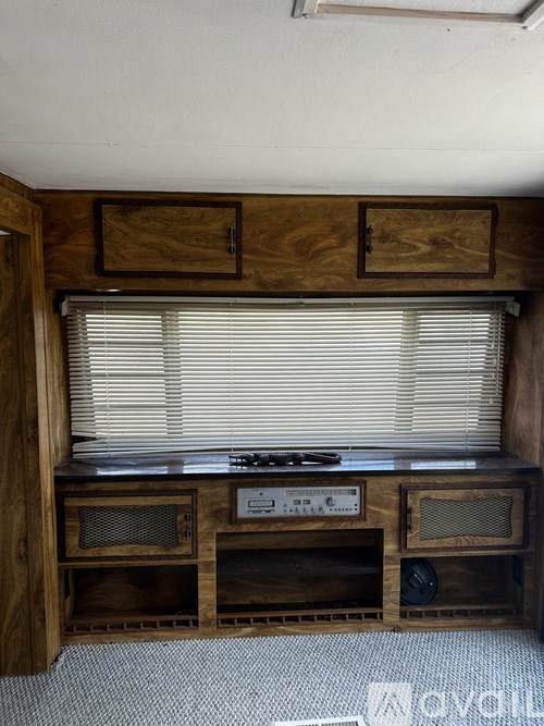 A wooden entertainment center with a television and speakers.