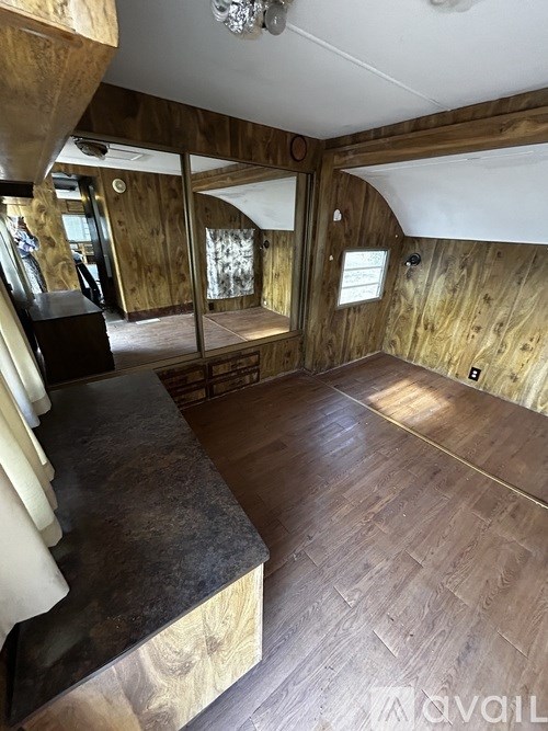 The image shows an interior space with wooden walls and flooring.