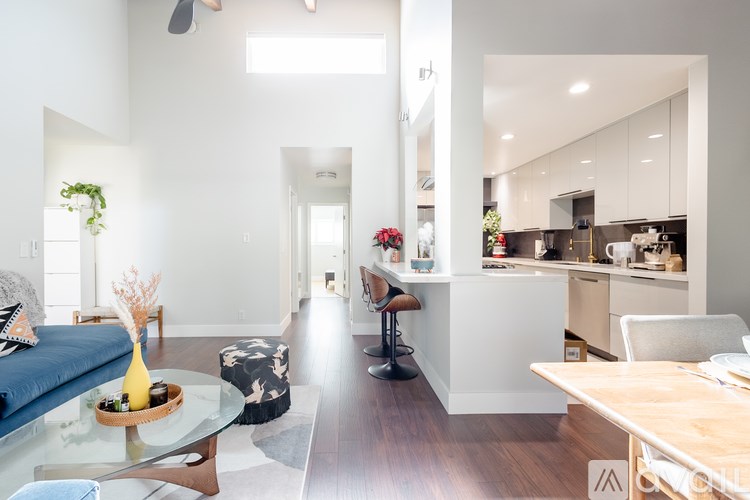 A modern living room with a blue couch and a glass table.