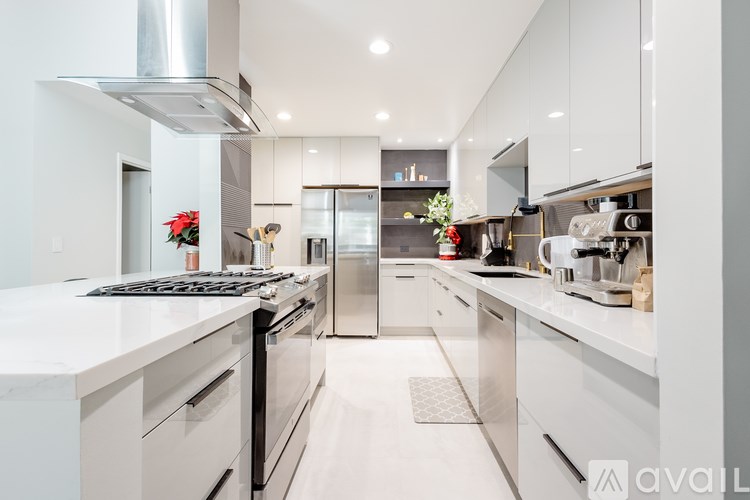 A modern kitchen with white cabinets and stainless steel appliances.