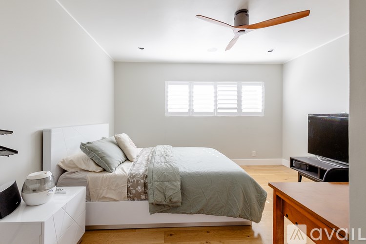 A bedroom with a bed, nightstand, and a television.