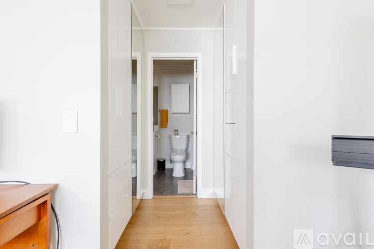 A bathroom with a toilet and sink is visible through an open door.
