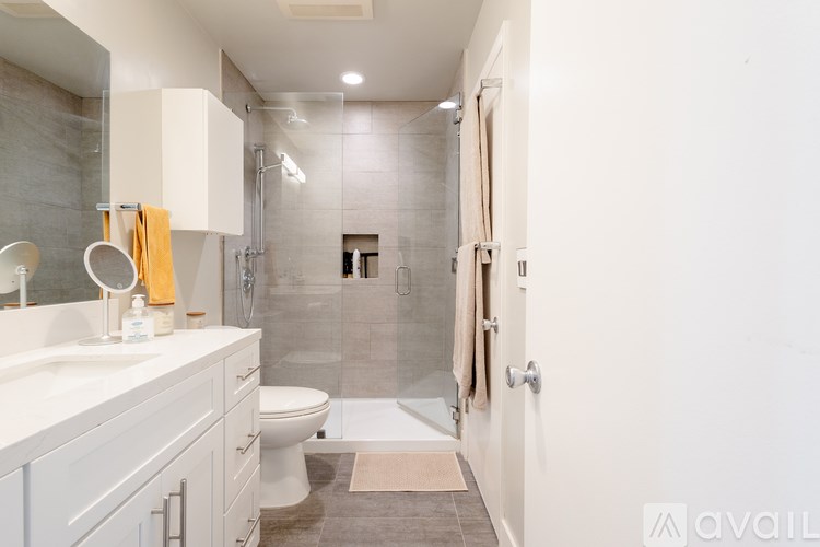 A bathroom with a toilet, sink, and shower.