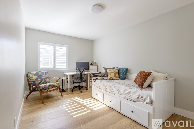 A bedroom with a bed, desk, and chair.