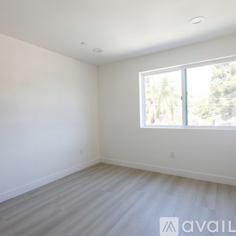 A room with a large window and wooden flooring.