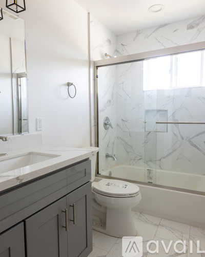 A bathroom with a toilet, sink, and mirror.