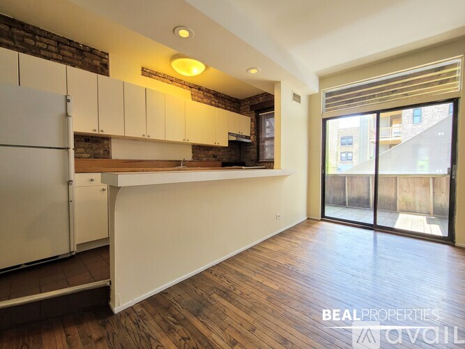 A kitchen with white cabinets and a brick wall.