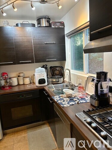 A kitchen with a white refrigerator, brown cabinets, and a black mat on the floor.