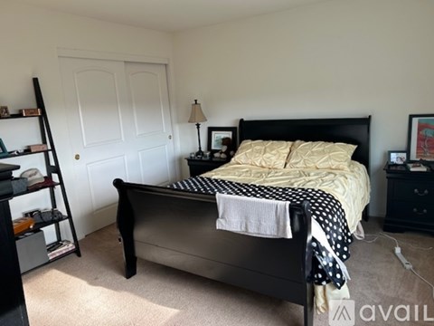 A bedroom with a black bed and a white door.