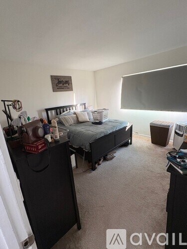 A bedroom with a floral bedspread and a black chair.