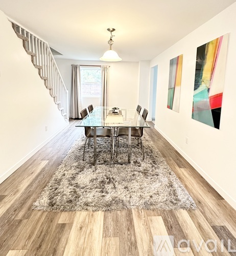 A dining room with a table and chairs.