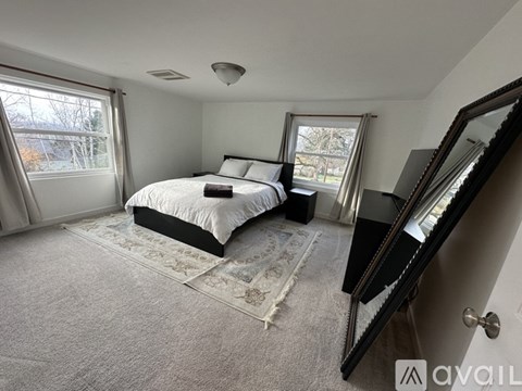 A bedroom with a large bed and a mirror on the wall.
