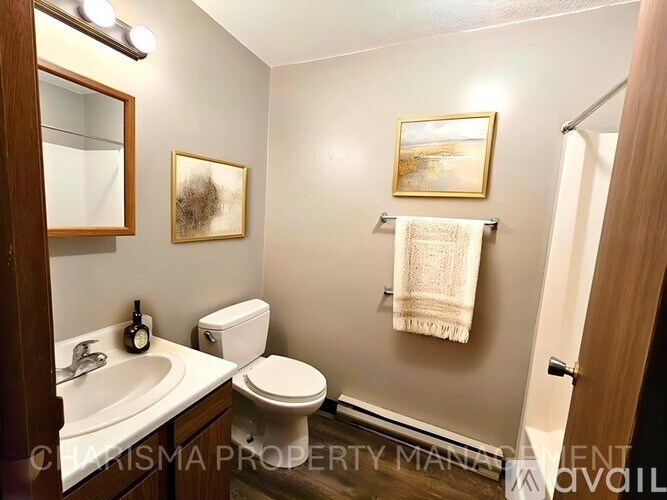 A bathroom with a toilet, sink, and towel rack.