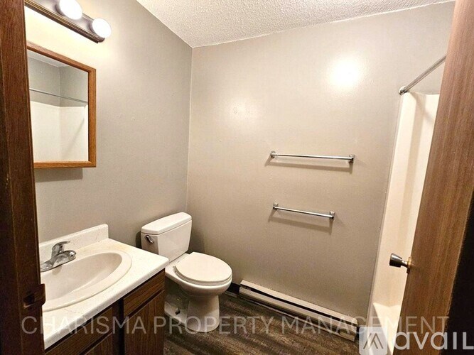 A bathroom with a toilet, sink, and towel rack.