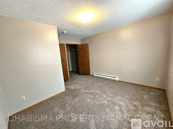 A room with a carpeted floor and a door in the background.