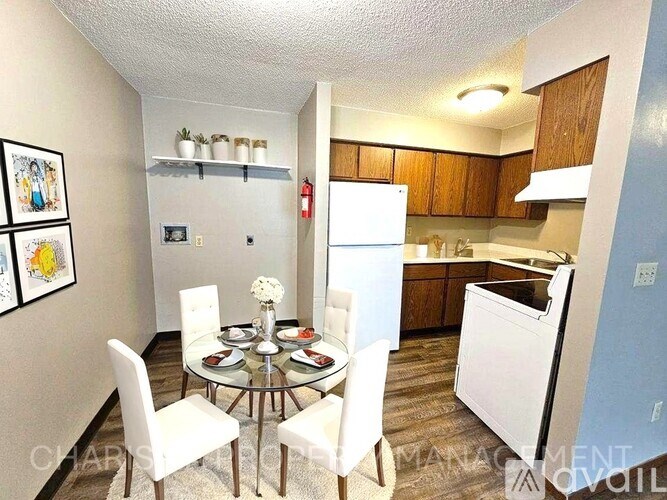 A kitchen with a dining table and chairs in the foreground.