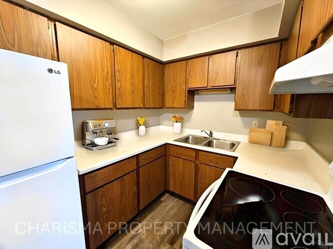 A kitchen with wooden cabinets and a white fridge.