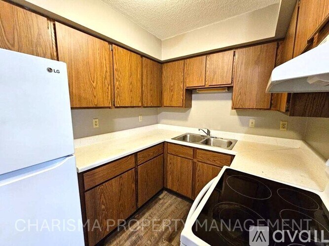 A kitchen with wooden cabinets and a white fridge.