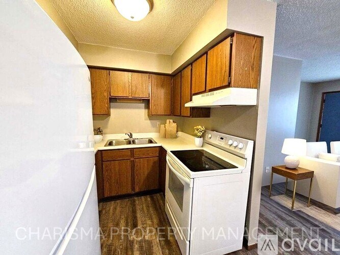 A kitchen with white appliances and wooden cabinets.