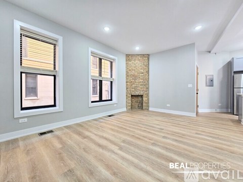 A white oven is in a kitchen with white walls and wood flooring.