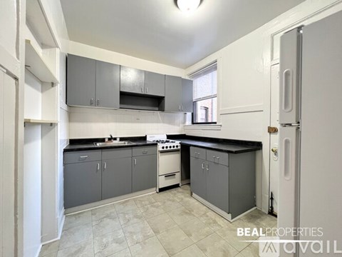 A kitchen with a white fridge and a black stove top.