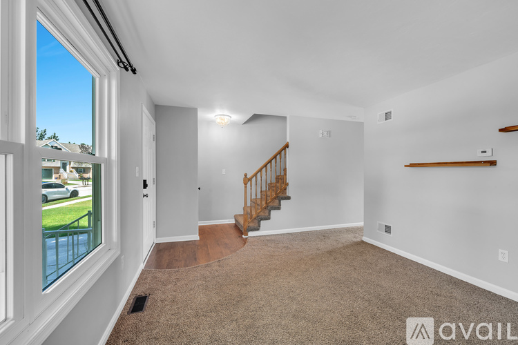 A spacious room with a staircase leading to the second floor.