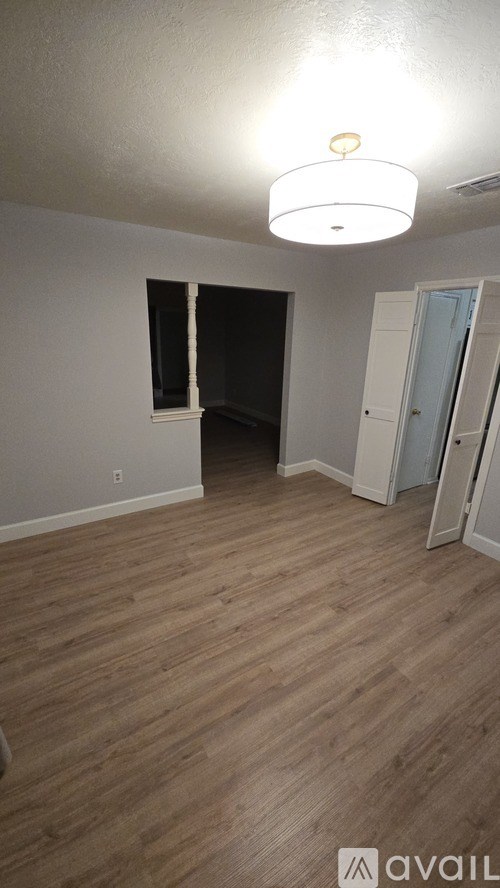 A room with wooden flooring and a ceiling light.