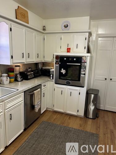 A kitchen with white cabinets and a black stove top oven.