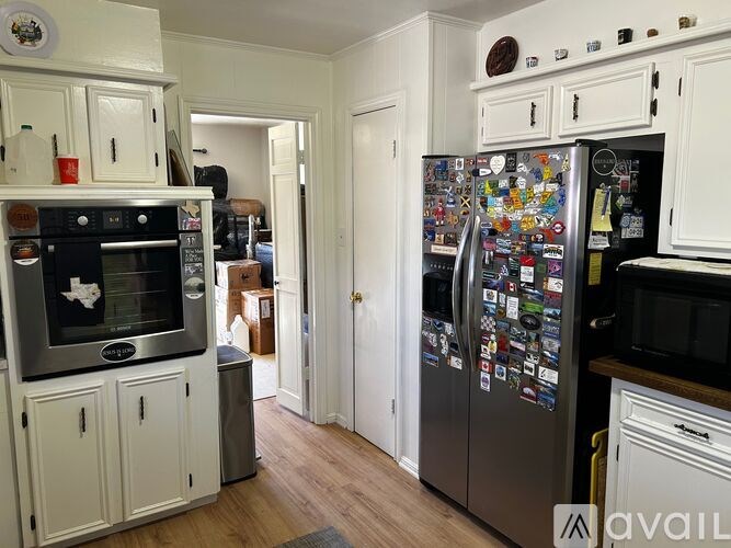 A kitchen with a refrigerator covered in magnets.