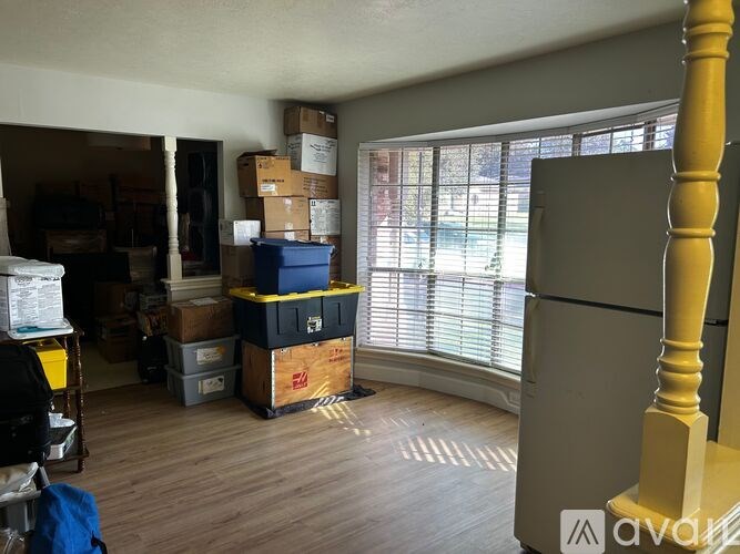 A room with boxes and a refrigerator.