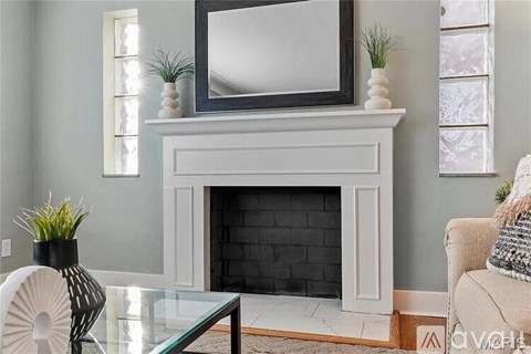A living room with a fireplace and a television above it.