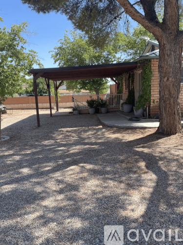 A patio area with a gravel ground and a tree.