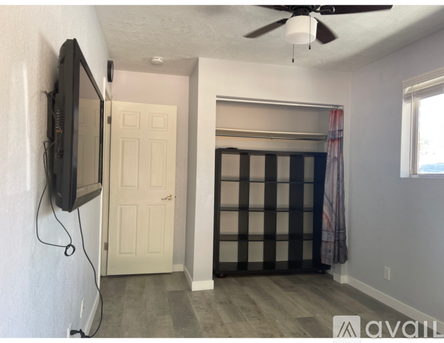 A room with a television on the wall and a sliding door.