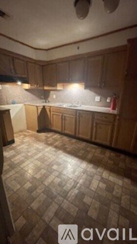 A kitchen with wooden cabinets and a checkered floor.