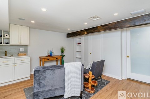 A grey couch sits in a living room with a wooden table and a glass door.