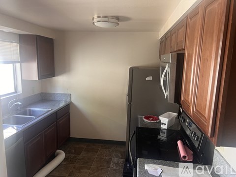 A kitchen with a black stove top and a refrigerator.