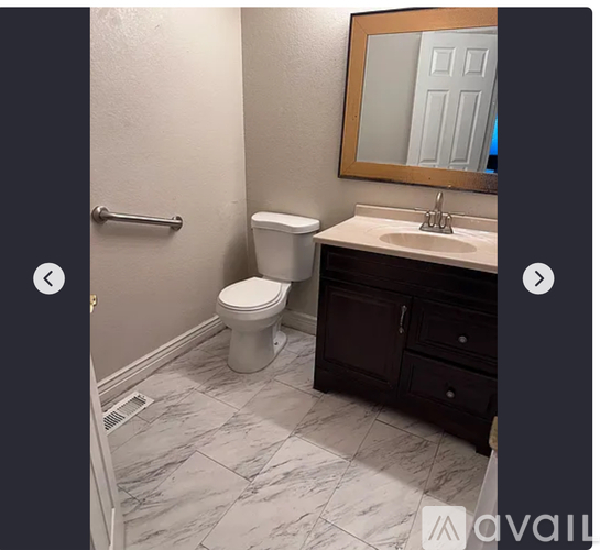 A bathroom with a toilet, sink, and mirror.