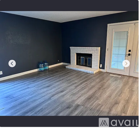 A room with a fireplace and wooden flooring.
