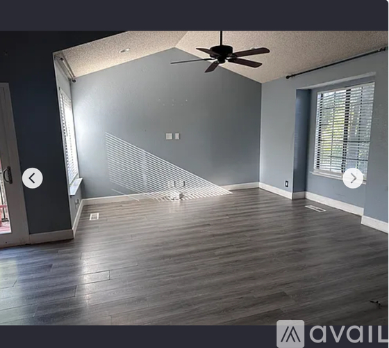 A room with a ceiling fan and wooden flooring.