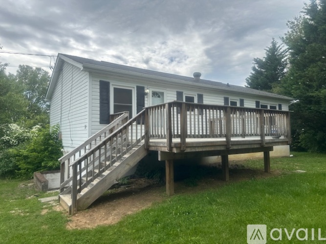 A house with a deck and a porch is available for rent.