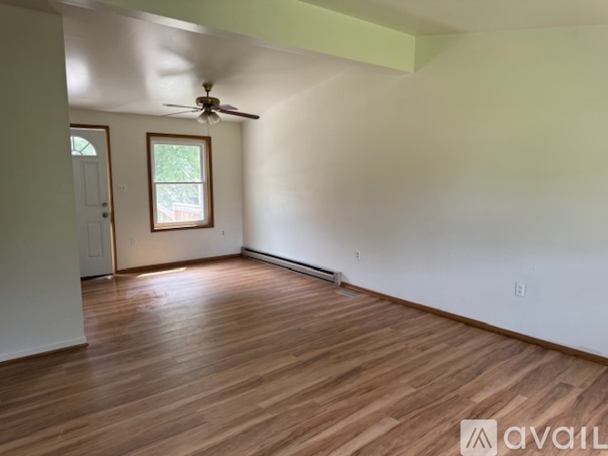 A room with wooden floors and a ceiling fan.