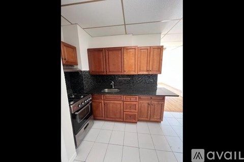A kitchen with wooden cabinets and a black countertop.