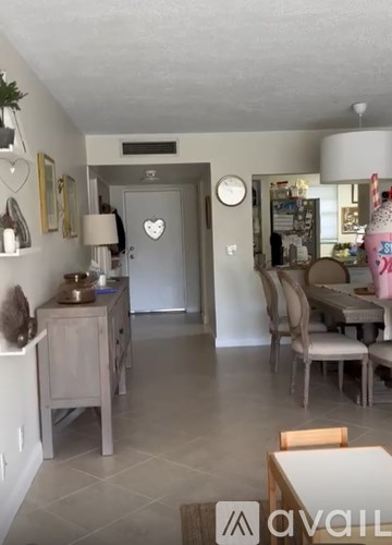 A living room with a grey door and a clock on the wall.