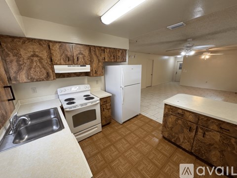 A kitchen with a white refrigerator, stove, and sink.