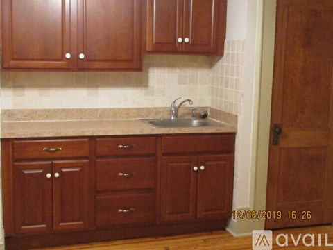 A kitchen with wooden cabinets and a marble countertop.