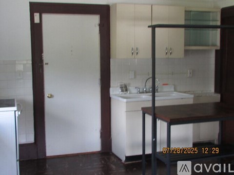 A kitchen with a white sink and a white door.