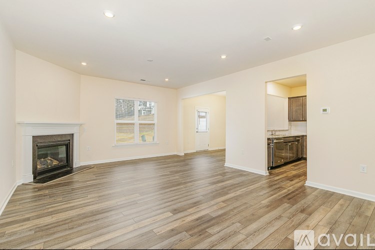 A spacious living room with a fireplace and wooden flooring.