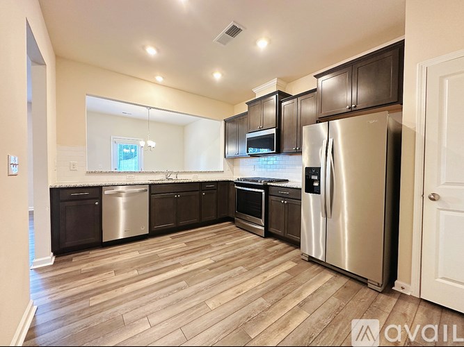 A kitchen with wooden floors and stainless steel appliances.