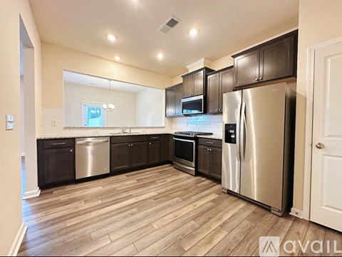 A kitchen with wooden floors and stainless steel appliances.