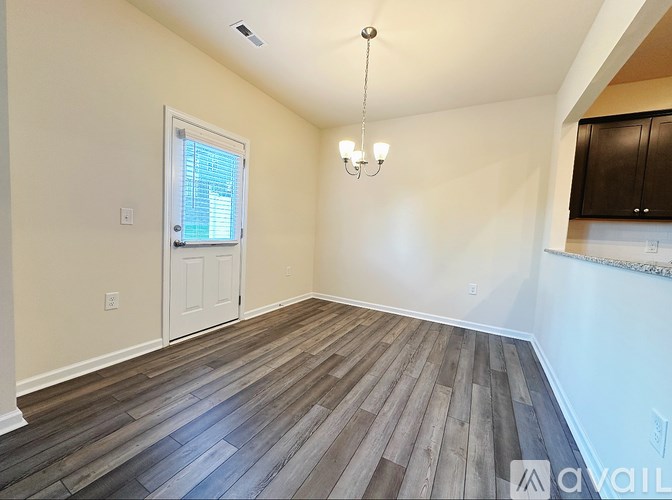 A room with wooden flooring and a chandelier.